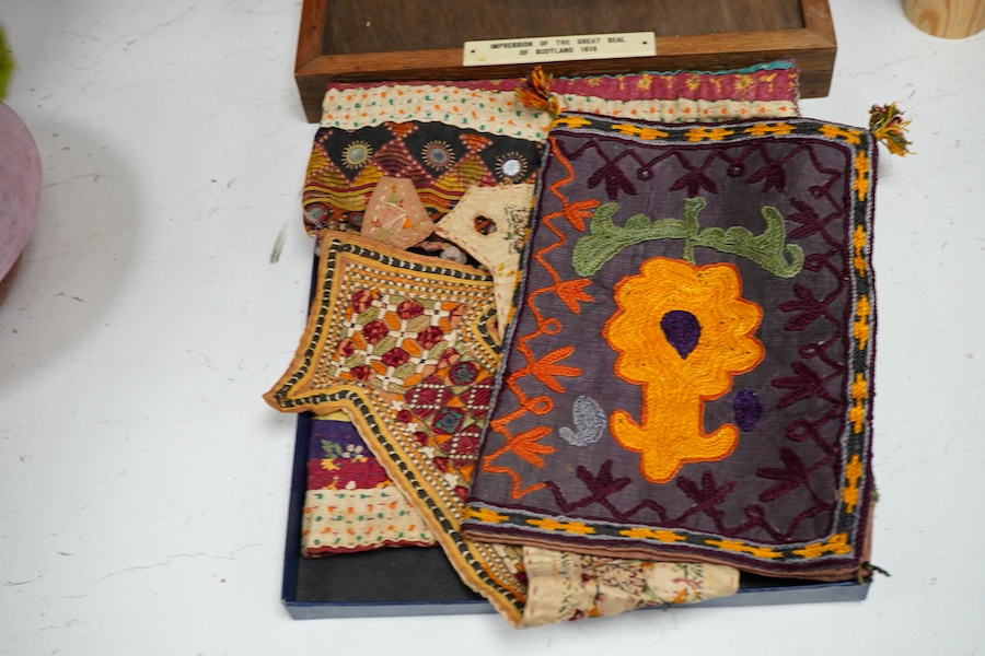 19th and 20th century textiles: An Indian mirrored and patchwork bag, a smaller embroidered bag, an ‘arrow’ shaped mirrored panel and two Omani shell and beaded ‘anchor’ shaped hangings, ‘arrow’ hanging 45cm long and two